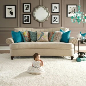 Cute baby sitting on bright carpet | Carpet Source